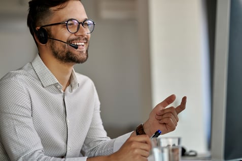 happy-call-center-agent-using-computer-while-communicating-with-clients-working-office (1)