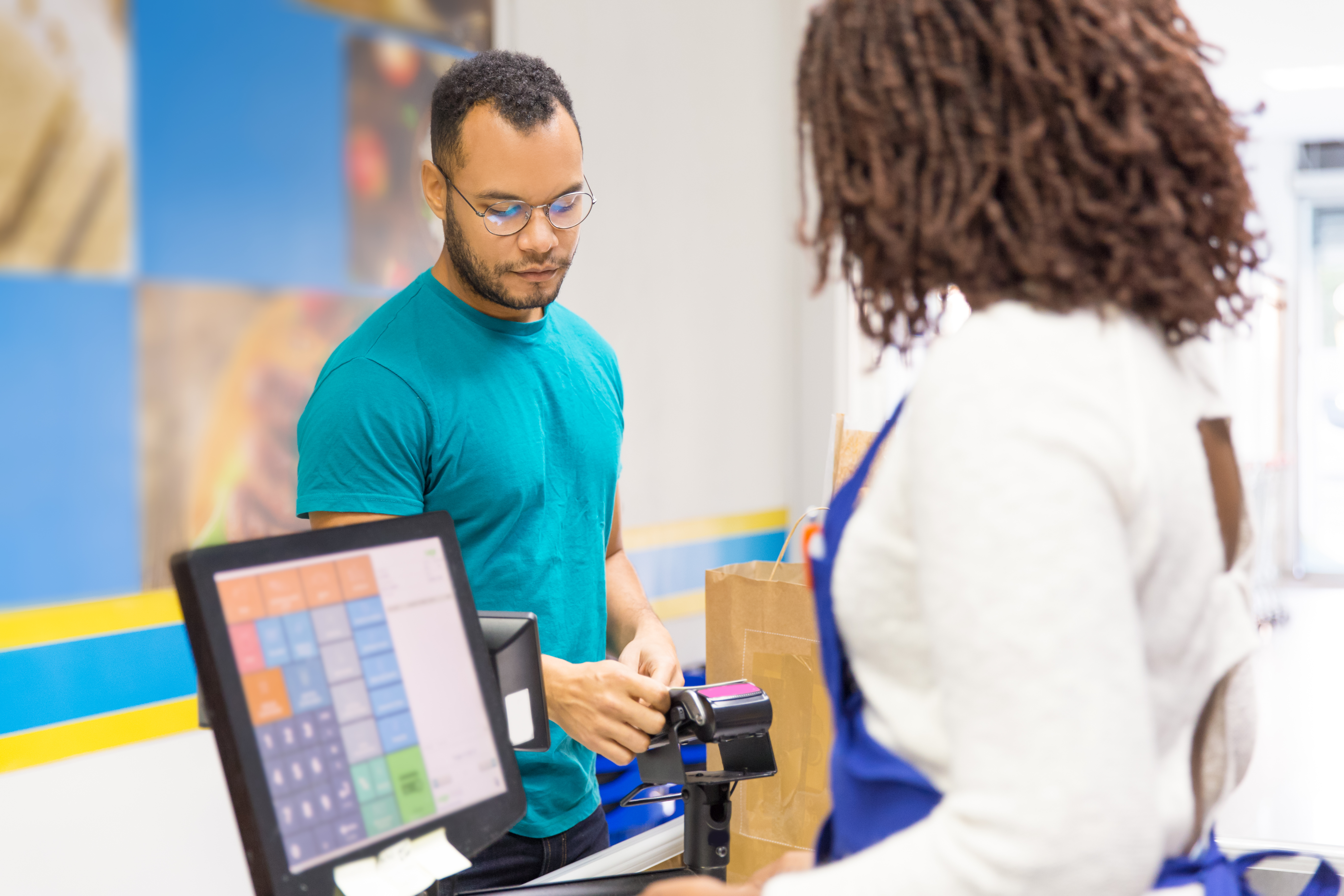 focused-young-man-paying-bill-store