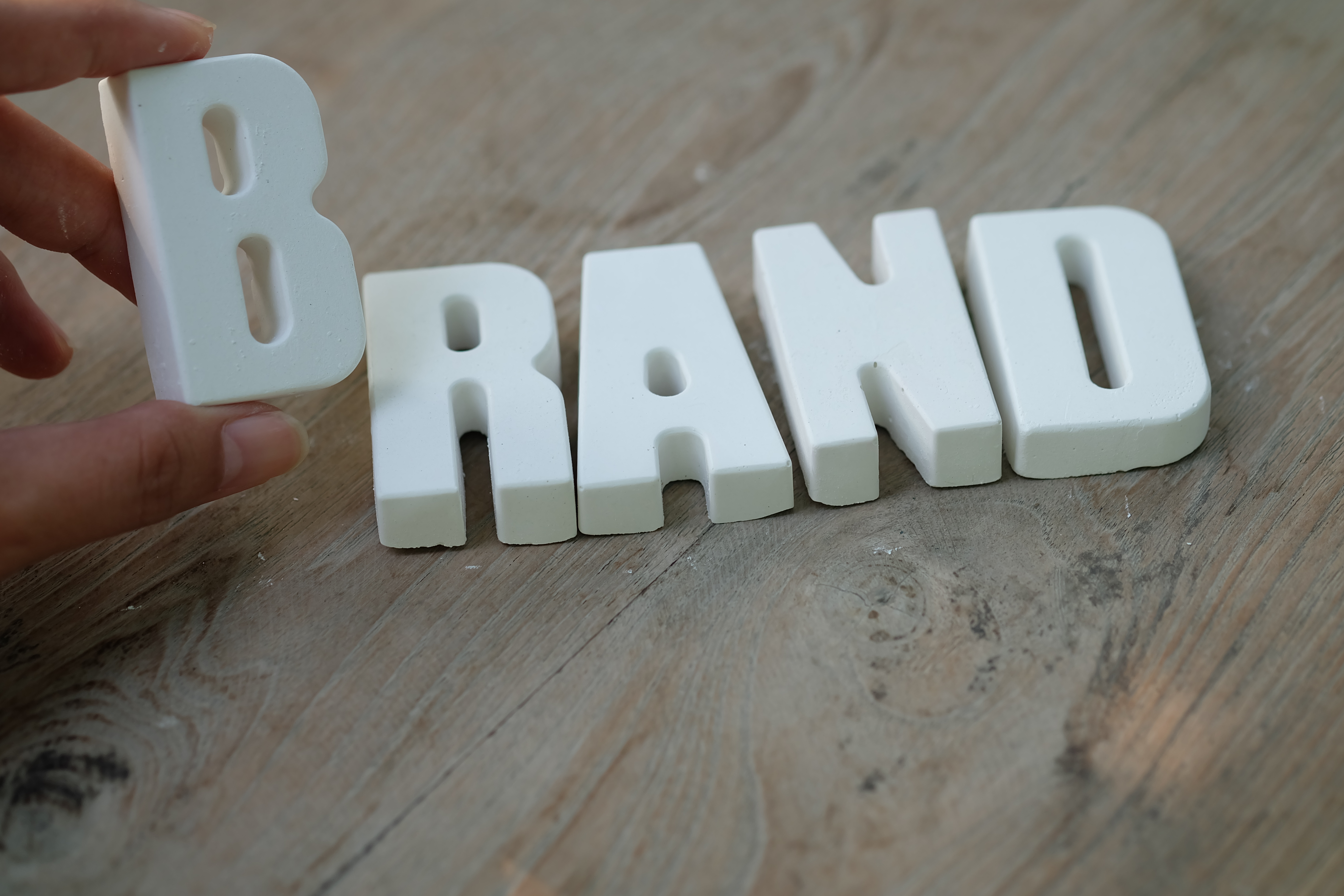 hand-arrange-white-letters-brand