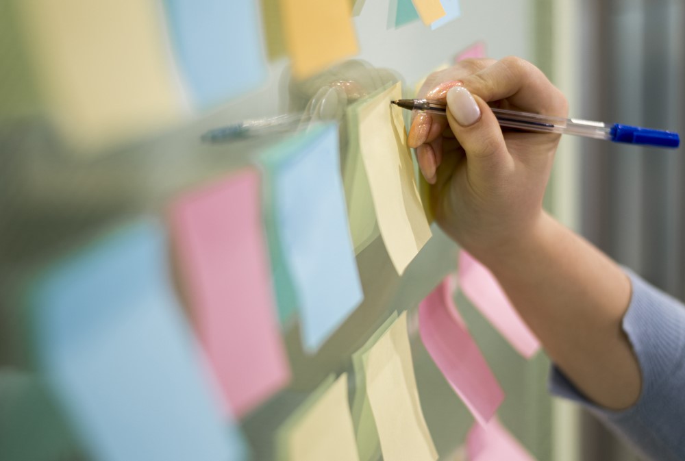 woman-writing-sticky-notes-office-window-1